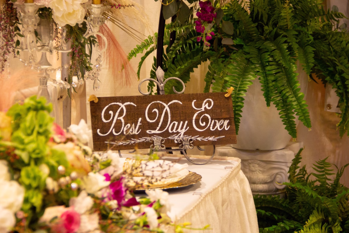 best day ever wedding sign puyallup bridal show - February 2027 Rustic wooden Best Day Ever wedding sign displayed on an ornate metal stand surrounded by lush fern greenery and colorful floral arrangements at the Puyallup Wedding Show in Puyallup Washington