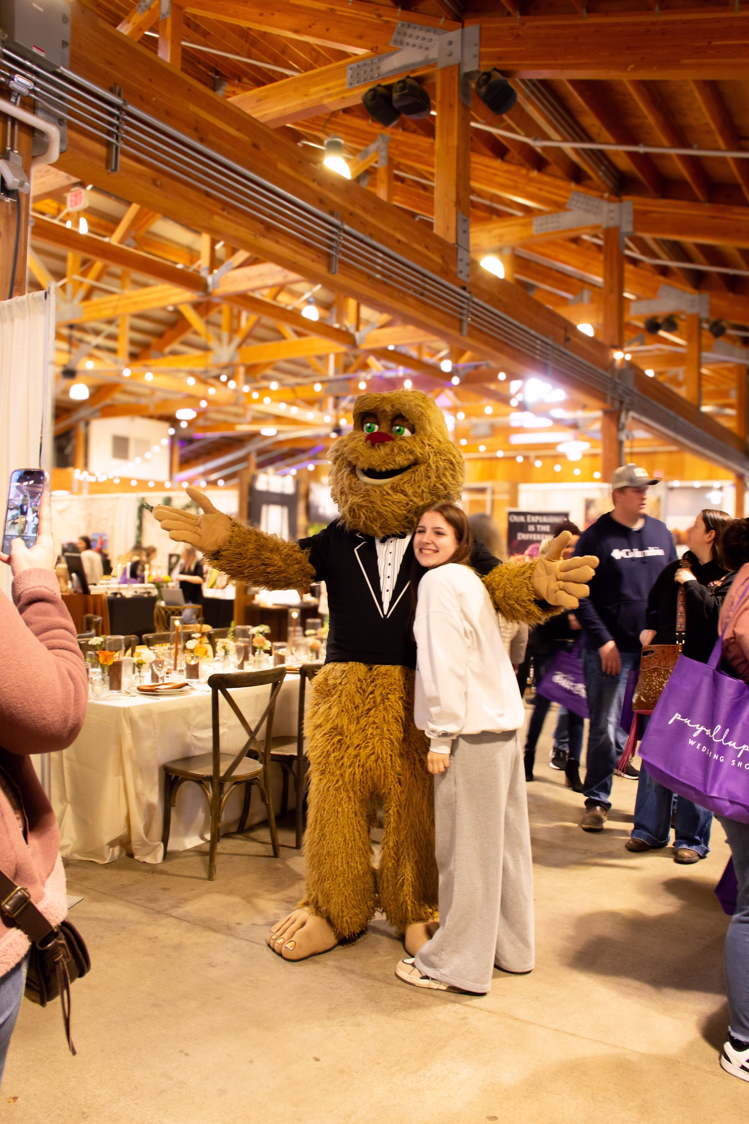 puyallup wedding show sasquatch mascot bridal - Exhibiting Information A smiling attendee poses with the Sasquatch mascot in a tuxedo at the Puyallup Wedding Show bridal expo in Puyallup Washington