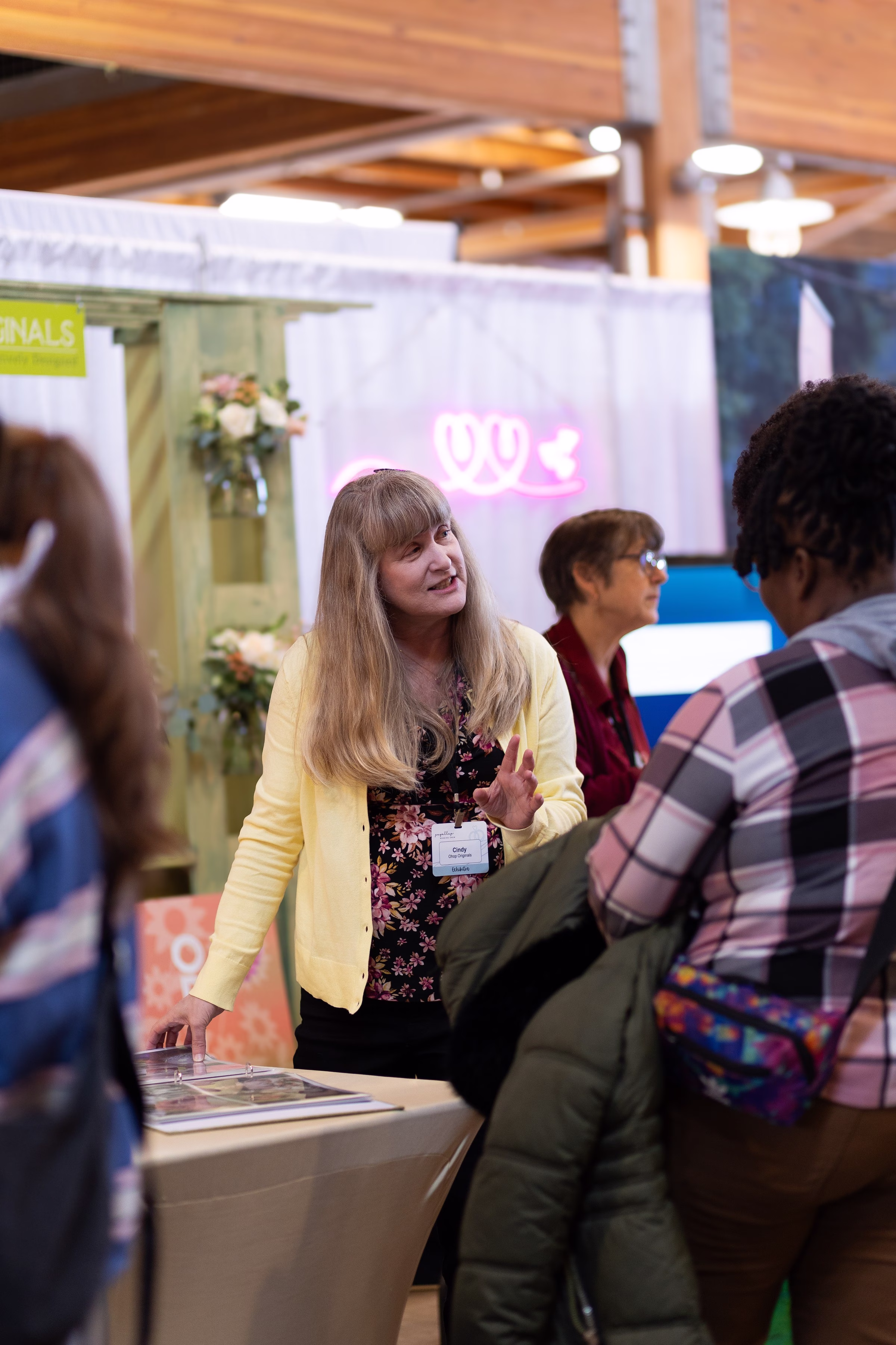 puyallup wedding show vendor booth exhibitor consultation - Exhibiting Information A wedding show exhibitor named Cindy speaks with attendees at her vendor booth during the Puyallup Wedding Show in Puyallup Washington