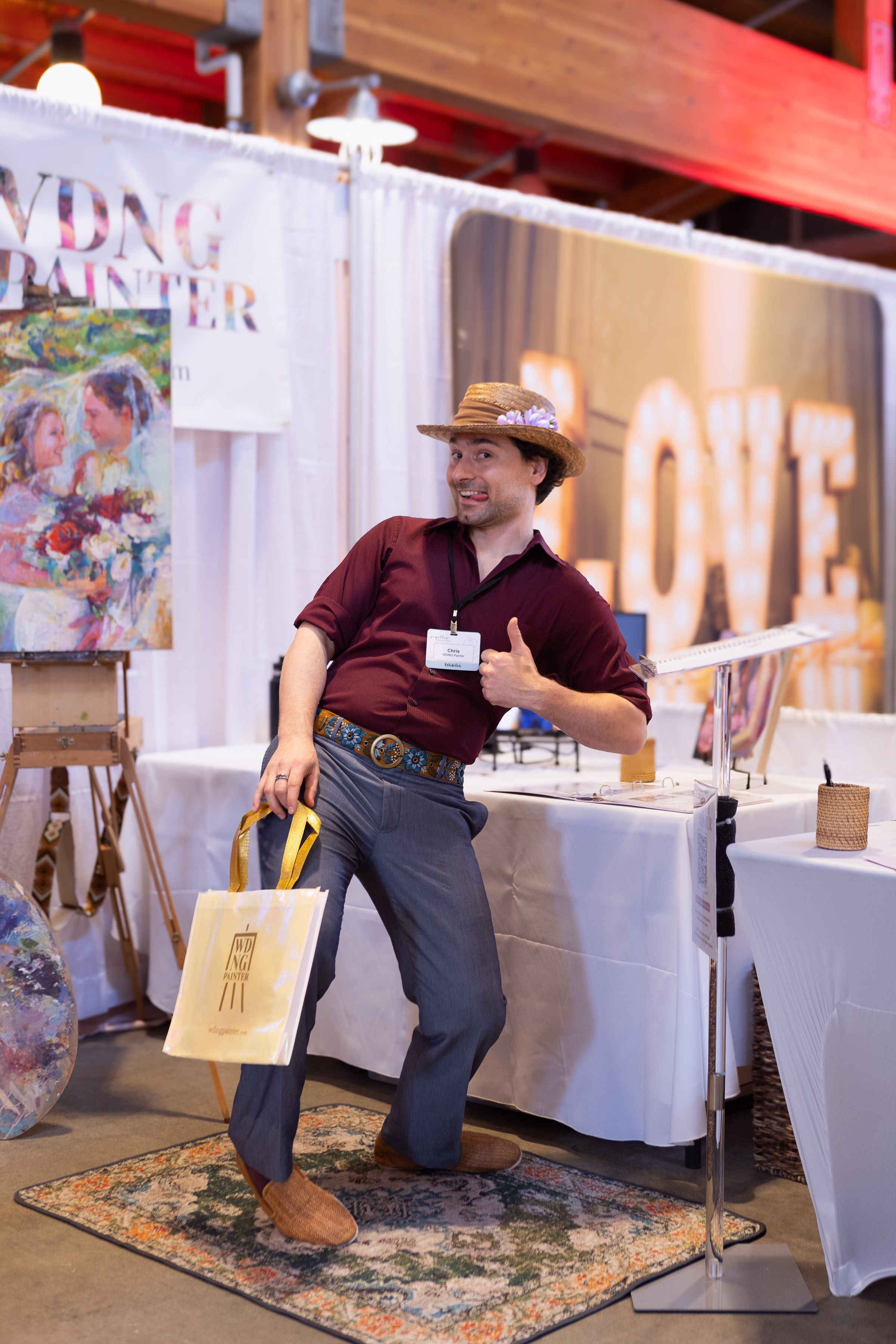 wedding painter vendor booth puyallup bridal show - The Puyallup Wedding Show Wedding Painter vendor Chris gives a thumbs up at his art booth displaying live wedding paintings at the Puyallup Wedding Show in Puyallup Washington